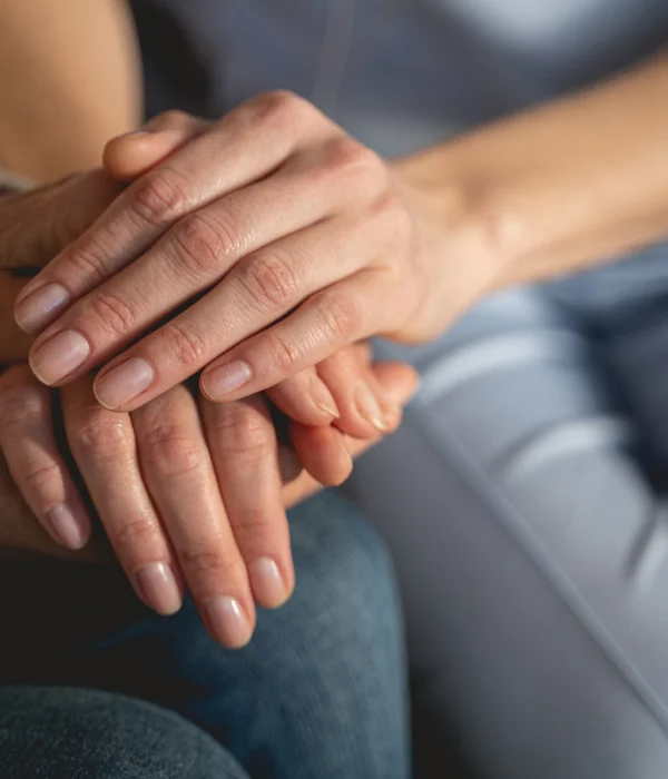 two peoples hands on top of each-others in support group